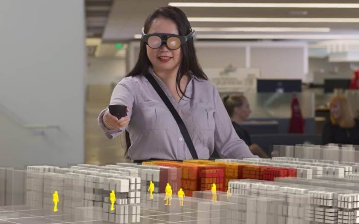 A person reviewing a scale model of a city block laid out in blocks